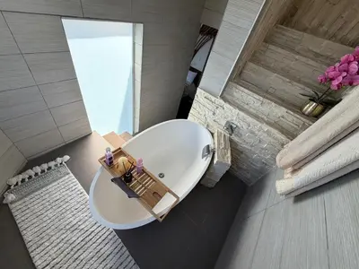 a bathroom with a large white tub in a room at Kiwara at C, Gordon's Bay in Gordonʼs Bay