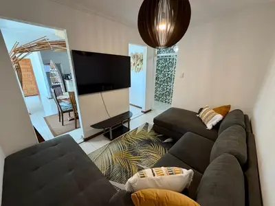 a living room with a couch and a flat screen tv at Kiwara at C, Gordon's Bay in Gordonʼs Bay