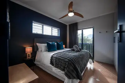 a bedroom with a bed with blue walls and a ceiling fan at Apartment Paradys 2 - Serviced in Stellenbosch