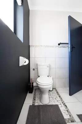 a bathroom with a toilet and a black door at Apartment Paradys 2 - Serviced in Stellenbosch