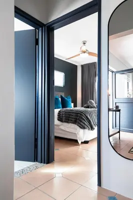 a bedroom with a bed and a mirror at Apartment Paradys 2 - Serviced in Stellenbosch
