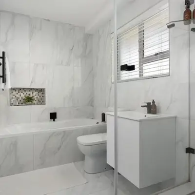 a white bathroom with a tub and a toilet and a sink at JC Mountain View in Cape Town