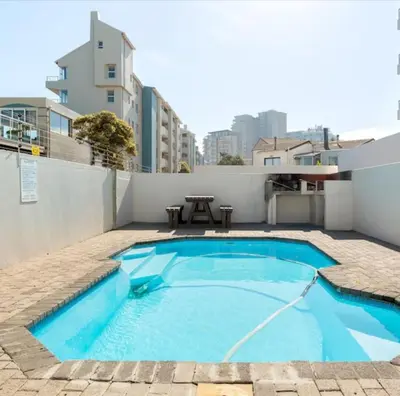 a small swimming pool with a picnic table next to a building at JC Mountain View in Cape Town