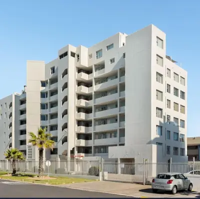 a white apartment building with a car parked in front at JC Mountain View in Cape Town
