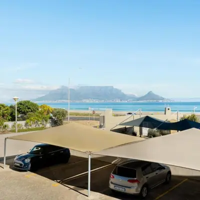 two cars parked in a parking lot with a large tent at JC Mountain View in Cape Town
