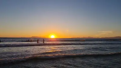 two people standing on the beach watching the sunset at The Art Room in Somerset West