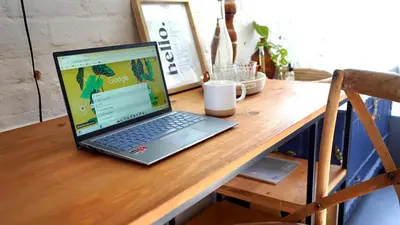 a laptop computer sitting on top of a wooden desk at The Art Room in Somerset West