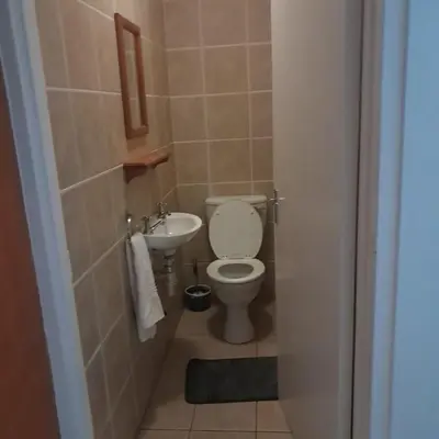 a small bathroom with a toilet and a sink at Cozy Corner in Cape Town