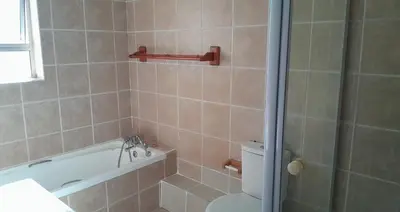 a bathroom with a tub and a toilet and a shower at Cozy Corner in Cape Town