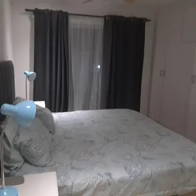 a bedroom with a bed with a white comforter at Cozy Corner in Cape Town