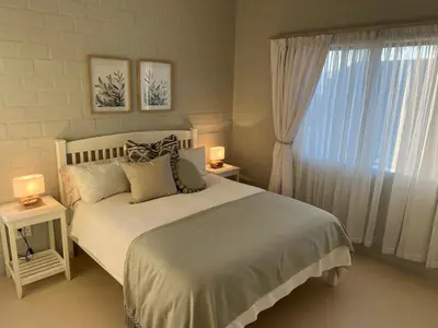 a bedroom with a white bed with two lamps and a window at Lagoon & beach paradise in Lake Marina