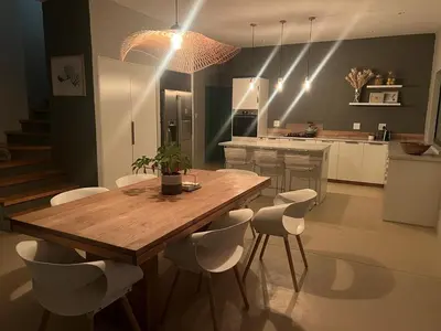 a kitchen with a wooden table and white chairs at Lagoon & beach paradise in Lake Marina