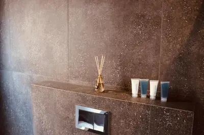 a bathroom with a shelf with four vases on it at 21b on SANDOWN in Cape Town