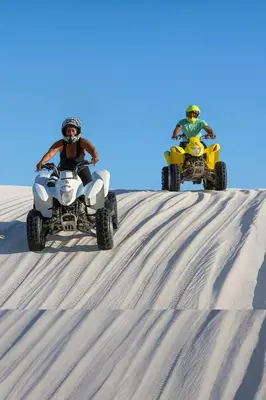 two people riding atvs on top of a sand hill at 21b on SANDOWN in Cape Town