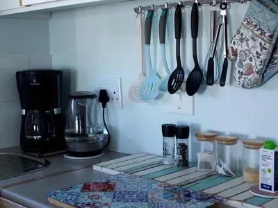 a kitchen counter with utensils hanging on a wall at Sea Urchin in Gordonʼs Bay