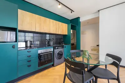 a kitchen with blue cabinets and a glass table at Nine Palms - Century City Luxury Apartment in Cape Town
