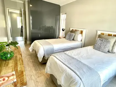 a hotel room with two beds and a mirror at Franschhoek Gem on Van Wijk in Franschhoek