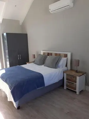 a bedroom with a large bed and a night stand at Franschhoek Gem on Van Wijk in Franschhoek