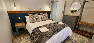 a bedroom with a large bed and a mirror at Overflowing Life - Accommodation near Paarl Gim in Paarl