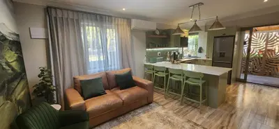 a living room with a couch and a kitchen at Overflowing Life - Accommodation near Paarl Gim in Paarl