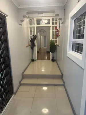 a hallway with a staircase in a building at Cozy Corner Guest House 25 Harpford avenue wynberg CAPE TOWN WESTERN CAPE in Cape Town