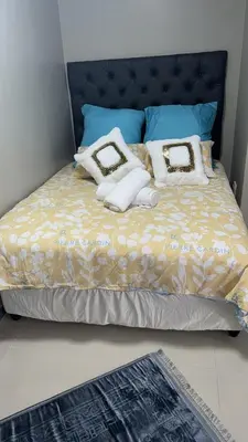 a bed with white towels and pillows on it at Cozy Corner Guest House 25 Harpford avenue wynberg CAPE TOWN WESTERN CAPE in Cape Town
