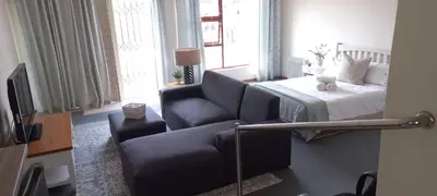 a living room with a couch and a bed at Cozy studio flat in Goodwood in Goodwood
