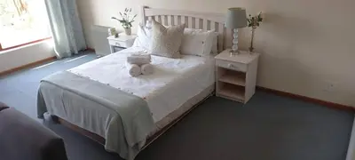 a bedroom with a bed with a teddy bear on it at Cozy studio flat in Goodwood in Goodwood