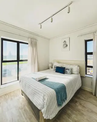 a bedroom with a large bed and a window at Shiloh Apartment on Burmeister in Cape Town