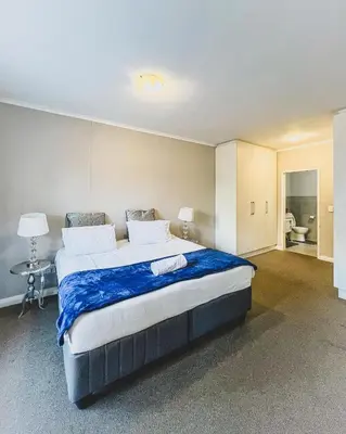 a bedroom with a large bed with a blue blanket at Spacious 2 bedroom Apt near Canal Walk in Cape Town