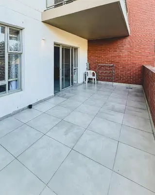 a large concrete patio with a brick wall at Spacious 2 bedroom Apt near Canal Walk in Cape Town