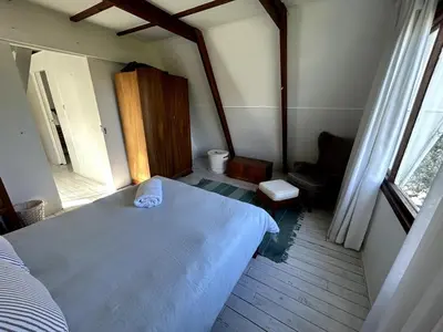 a bedroom with a white bed and a window at Protea Escape - sea, sand and sun on your doorstep in Hermanus