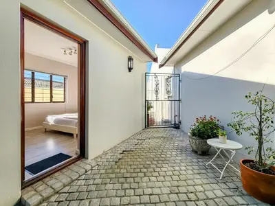 a room with a door leading to a bedroom at Tranquil Garden Cottage in Cape Town