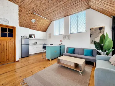 a living room with a couch and a table at The Nest at Durbanville in Cape Town