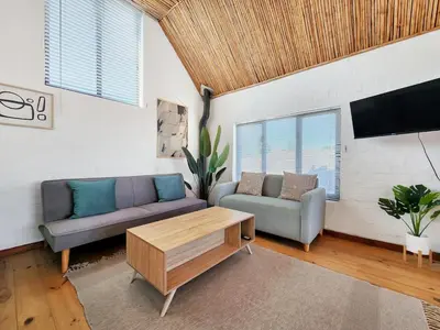 a living room with a couch and a table at The Nest at Durbanville in Cape Town