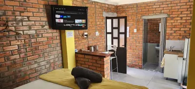a room with a tv on a brick wall at LyonsDen 1 in Worcester