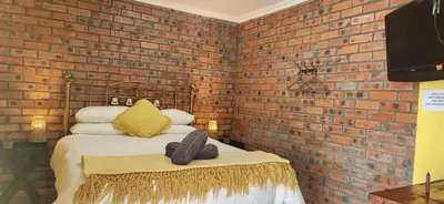 a bedroom with a brick wall and a bed at LyonsDen 1 in Worcester