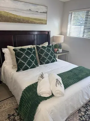 a bedroom with a large bed with two pillows on it at Ziminé Cottage in Paarl