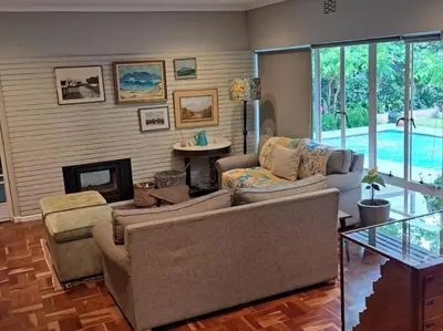 a living room with a couch and a fireplace at Spacious Sunny family home in secure leafy sought after area in Stellenbosch
