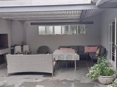 a patio with a table and a couch at Spacious Sunny family home in secure leafy sought after area in Stellenbosch