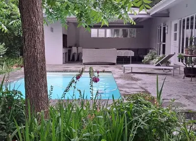 a swimming pool in the backyard of a house at Spacious Sunny family home in secure leafy sought after area in Stellenbosch