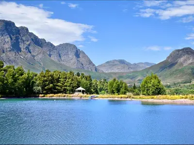 a view of a lake with mountains in the background at La Jolie Dauphine Guest House in Franschhoek