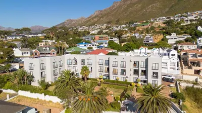 an aerial view of a city with buildings and palm trees at Ocean & Mountain View Escape, 100m Walk to beach - Gordon's Bay in Gordonʼs Bay