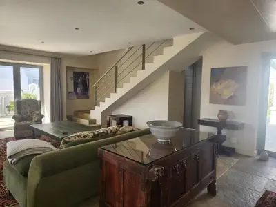 a living room with a green couch and stairs at Stellenbosch family villa in Stellenbosch