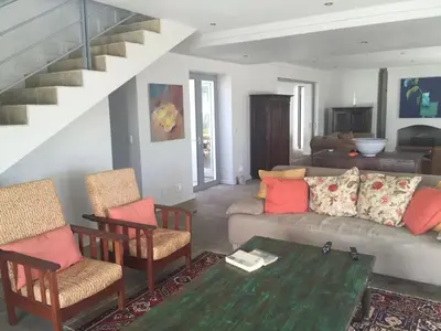 a living room with a couch and chairs and a staircase at Stellenbosch family villa in Stellenbosch
