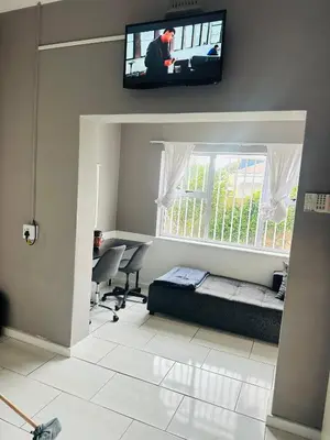 a bedroom with a bed and a tv on the wall at AAA Luxury Homes in Cape Town