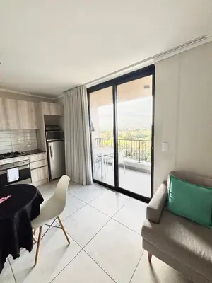 a kitchen and living room with a table and a couch at Luxe Waters Edge apt next to Canal Walk in Cape Town