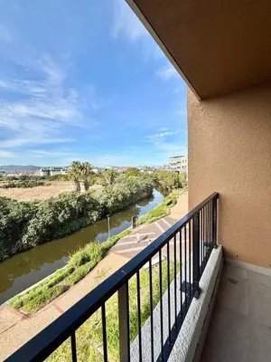 a balcony with a view of a river at Luxe Waters Edge apt next to Canal Walk in Cape Town