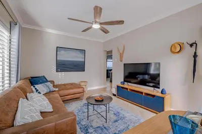 a living room with a couch and a flat screen tv at Belle Apartment in Hermanus