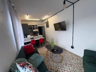 a living room with a couch and a kitchen at TLP Haven in Cape Town